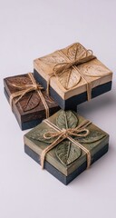 Three square coasters,  each with a leaf design, tied with jute twine.  Light beige, dark brown, and muted green tones
