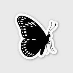 Black silhouette of a butterfly with white polka dot patterns on wings