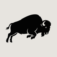 Silhouette of a charging bison in profile against a light background