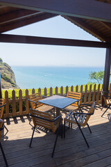 Cliffside Cafe Deck With Shaded Table and Ocean Panorama
