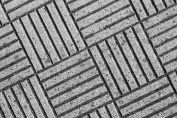 Textured concrete surface with diagonal grooves and patterns in a monochrome setting
