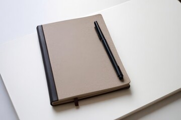 Notebook and pen placed on table for writing or note taking