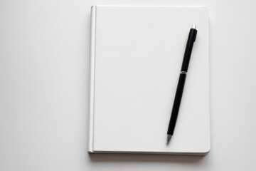 Notebook and pen placed on table for writing or note taking