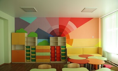 Desks, chairs and shelving unit near bright wall in classroom