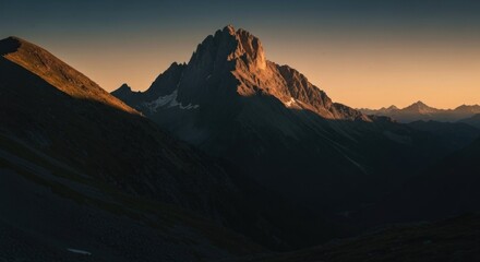 Mountain peak bathed in golden sunset light, dramatic mountain range