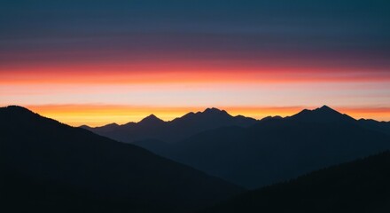 Silhouettes of mountain ranges bathed in a vibrant sunset