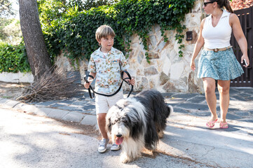  Child leading fluffy dog in a suburban walk