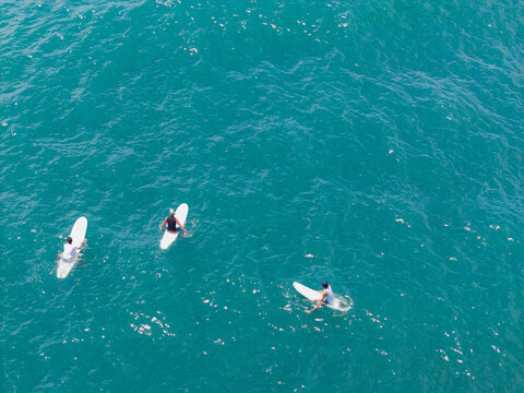 Surfers waiting for waves in turquoise ocean
