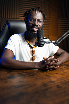 Radio host speaking into microphone in recording studio