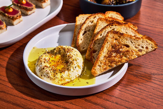 Fresh Bread with Cheese, Olive Oil, and Herbs, framed by Appetizers