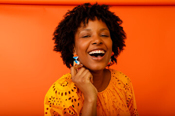 Bright Smile of a Woman With Curly Hair in a Colorful Setting