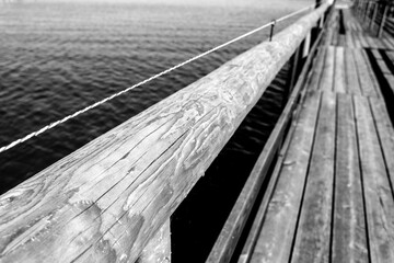 Wooden pier railing in the lake in black and white
