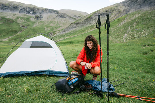 hungry young woman having a snack of saucisson on a hiking trip