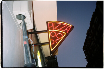 illuminated pizza sign at night, 35mm