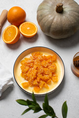 Healthy dessert with sliced pumpkin, honey and orange juice in a bowl. Healthy pumpkin dish.