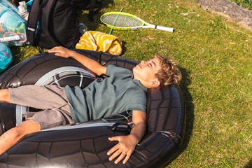 Kid Resting Peacefully in a Donut-Shaped Float on the Grass