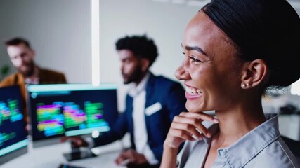 Software development team working on project with smiling female colleague in focus. - Powered by Adobe