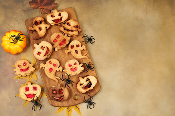 Scary ghost cookies,ghosts and pumpkins on old concrete background,cafe advertisement and menu,restaurant business card,Halloween food concept,idea for cooking holiday dishes for kids and adults.