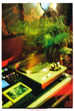 Vibrant turntable in a bustling nightclub captured on film camera