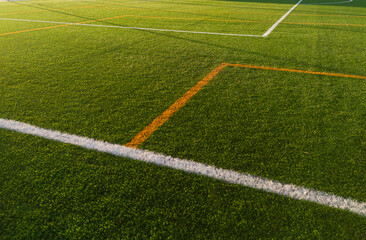 Obraz premium Synthetic turf of soccer field at sunset