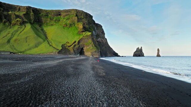 Aerial drone footage of Reynisfjara Iceland black sand shoreline. Waves crash against volcanic beach in cinematic 4K natural landscape.