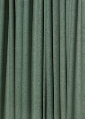 Soft green curtain fabric draping elegantly in a cozy indoor space with light filtering through