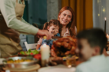 Family enjoying thanksgiving dinner with roasted turkey