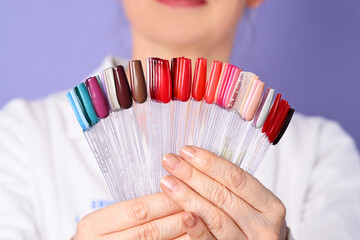Female beautician holding nail polish palette set for manicure