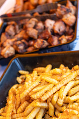 Sizzling street food feast: grilled sausages, shashlik, and golden french fries