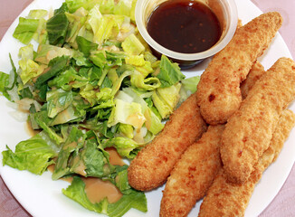 Crispy oven baked breaded chicken strips with a honey garlic dipping sauce.   Also a side salad with a light vinaigrette dressing