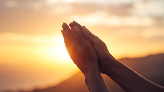 Hands reach skyward towards a glowing sun with blurred clouds in the background