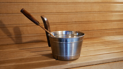 Metal Sauna Bucket with Ladle on Wooden Bench. Russian Traditional Sauna