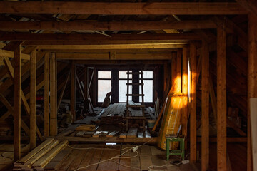 Fototapeta premium attic framework shows an interior filled with beams and tools, suggesting an ongoing renovation project in the space with the natural wood and light.