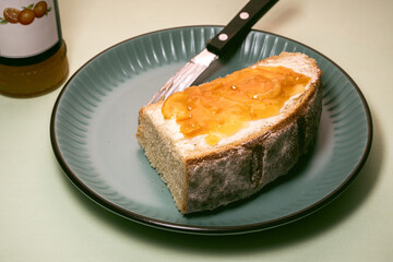 A slice of country bread with butter and jam