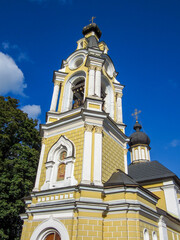 Orthodox church bell tower with bells against blue sky.