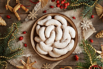 Homemade Christmas cookies called Kipferl or vanilla crescents coated in sugar on a plate with...