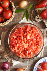 Peeled chopped tomatoes in a bowl and spices - preparation of homemade tomato relish (ajvar-style vegetable spread, chutney or bruschetta topping)