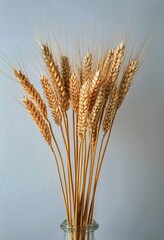 Fototapeta premium Dried Wheat Stalks Arranged in a Decorative Bouquet Against a Light Background.