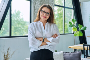 Portrait confident middle aged businesswoman posing with crossed arms