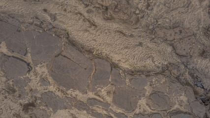 Closeup aerial view of cracked lava field in Iceland showing volcanic textures, rugged surface patterns, and dramatic barren landscape