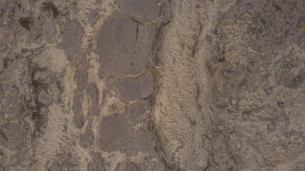 Iceland volcanic rock formations with rough cracked lava surface captured from above highlighting natural geology and raw barren beauty