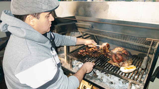 Man grilling meat outdoors on a sunny day