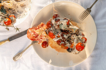 Toxic mold fungus on forgotten cherry tomatoes and ham on the plate