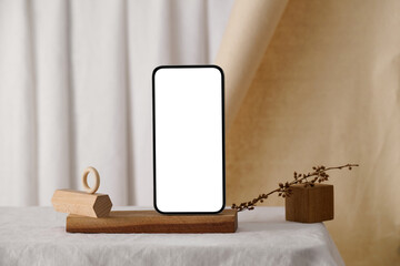 Minimalist smartphone mockup showcasing blank screen on a wooden