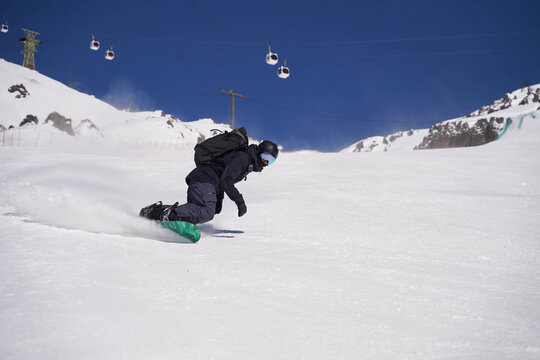 Powerful snowboard carve in alpine sunlight