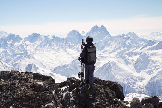 Snowboarder taking photo of mountain view

