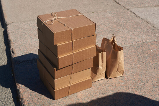 Stack of cardboard boxes and paper bags displayed on a sidewalk