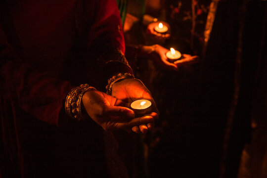 Group of Indian friends with candles lights celebrating Diwali night.