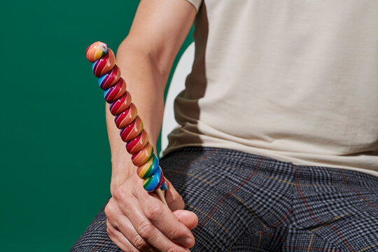 man holding spiral lollipop against green background