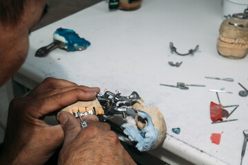 Dental technician adjusting metal bridge